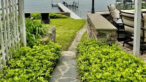 A gazebo with a view of a lake, a pathway, and outdoor seating.