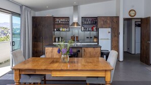 Une cuisine moderne avec des meubles en bois, un îlot central et un coin repas comprenant une table et des chaises en bois.
