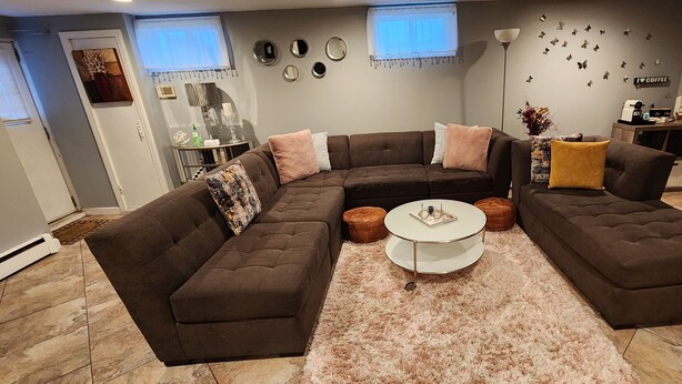 Una sala moderna con un sofá modular, una mesa de centro y decoración en la pared.