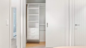 A walk-in closet with open doors, revealing shelves and drawers. - Studio Guest Home with Roys Peak Views (Wānaka)
