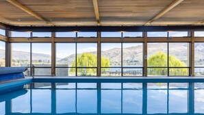 En swimmingpool med utsikt över berg och en sjö.