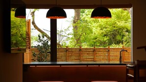 A room with a large window, wooden bench seating, and hanging pendant lights. - Sanjoubou Sansou villa (Kyoto)