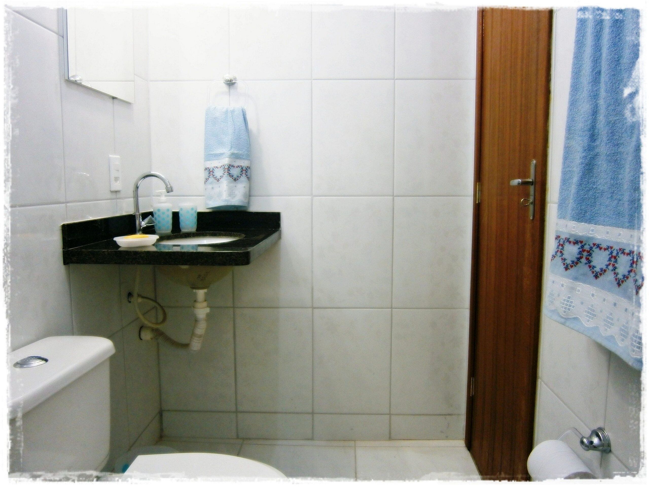 A small bathroom with a toilet, sink, and shower.