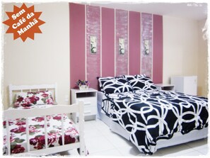 Cozy retreat with a geometric-patterned bed, white headboard, and floral accents.