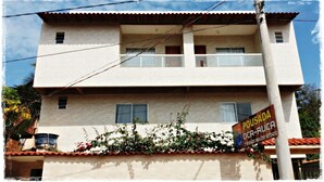 A two-story building with a balcony on the second floor. - Hospedaria Oca Ruca (Guarapari)