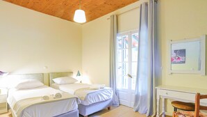 A room with two beds, a desk, and a chair. - Escape to Serenita Villa in Arillas, Corfu - Private Pool, Sunset Views, and More (Arillas)