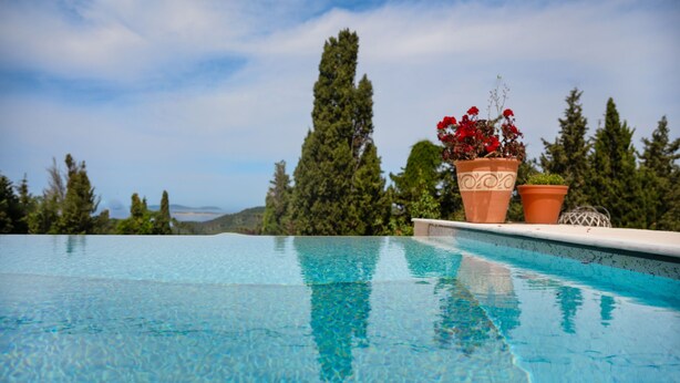 A clear blue pool with terracotta pots containing red flowers. - Escape to Serenita Villa in Arillas, Corfu - Private Pool, Sunset Views, and More (Arillas)