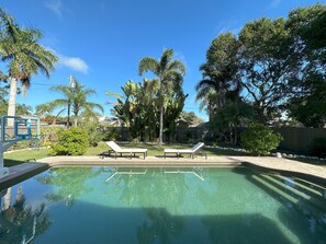 Une piscine aux eaux cristallines, agrémentée de deux chaises longues et d’un panier de basketball.