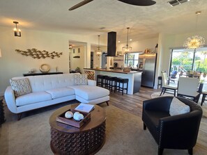 A modern living room with a sectional sofa, a coffee table, and a black armchair.