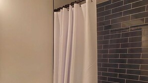 A bathroom with a toilet, a shower curtain, a bathtub, and a wooden cabinet. -  ★Cozy Apt Near SLU Hospital & Other Major Hospitals ★ (St. Louis)