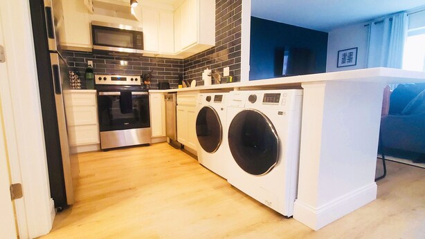 A compact kitchen with a microwave, oven, and washing machine. -  ★Cozy Apt Near SLU Hospital & Other Major Hospitals ★ (St. Louis)