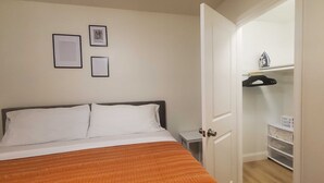 A bedroom with a bed, a nightstand, a wardrobe, and a door leading to another room. -  ★Cozy Apt Near SLU Hospital & Other Major Hospitals ★ (St. Louis)