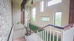 A staircase with white railings and a wooden ceiling. - Jepun Guest House (Mataram)