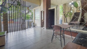 A modern interior with a dining area, a staircase, and a view of the outdoors. - Jepun Guest House (Mataram)