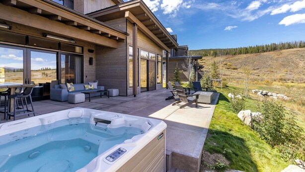 Una casa moderna con jacuzzi, mobiliario exterior y vistas panorámicas.