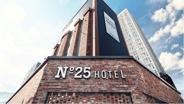 Un cartel de hotel con la inscripción 'N°25 HOTEL' sobre un muro de ladrillo.