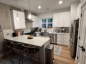 Een magnetron, een vaatwasser, kookgerei, borden en bestek, keukenrol