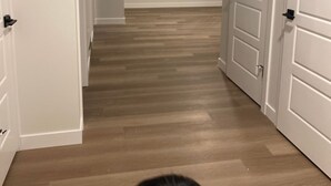 A hallway with wooden flooring and white doors. - New, fresh, affordable, homey, 10 mins to the Edmonton Intl Airport. (Edmonton)