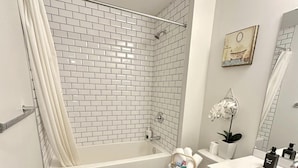 A modern bathroom with a shower, toilet, and sink. - New, fresh, affordable, homey, 10 mins to the Edmonton Intl Airport. (Edmonton)