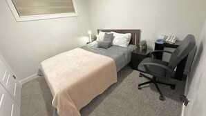 A bedroom with a bed, bedside tables, a desk, and a chair. - New, fresh, affordable, homey, 10 mins to the Edmonton Intl Airport. (Edmonton)