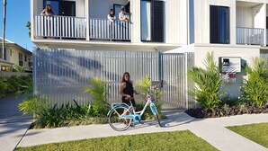 Un edificio moderno con balcón, una persona en bicicleta y un cartel que indica 'Mi Haven Pembroke St'.