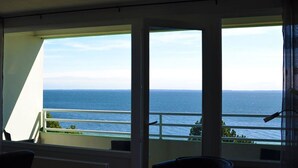 A room with a view of the sea through large windows.