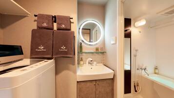 A bathroom with a sink, mirror, and towel rack.