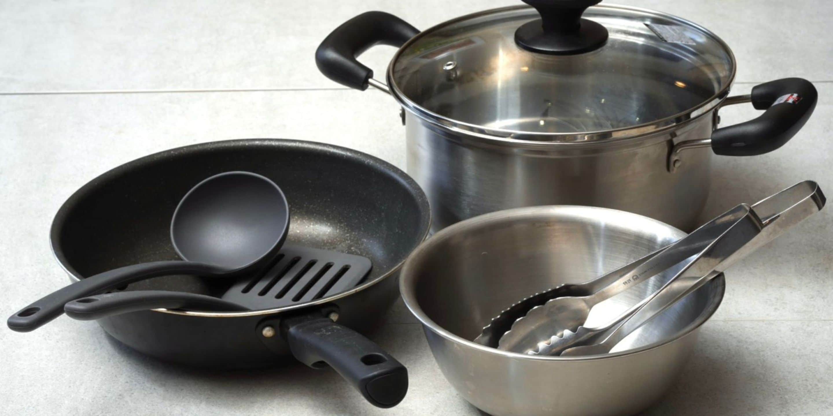 Een keuken met een koekenpan, spatel en een pan met deksel.
