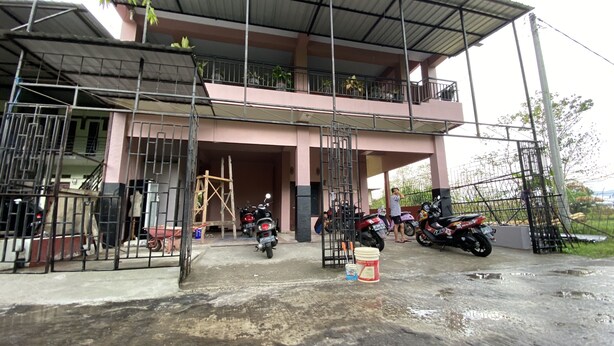 A building with a covered entrance, a balcony, and several parked motorcycles. - OYO 93414 Wisma Ratu Syariah Near SMP Negeri 2 Watang Pulu (Watang Pulu)