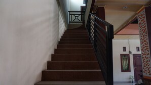 A staircase with a black railing leading to an upper floor. - OYO 93414 Wisma Ratu Syariah Near SMP Negeri 2 Watang Pulu (Watang Pulu)