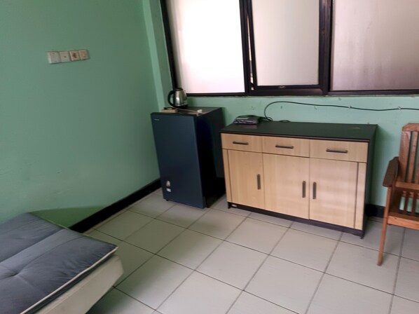 A small room with a bed, a desk, a cabinet, and a chair.