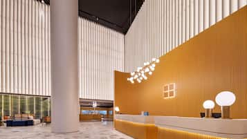 A spacious lobby with a reception desk, seating area, and a large pillar.