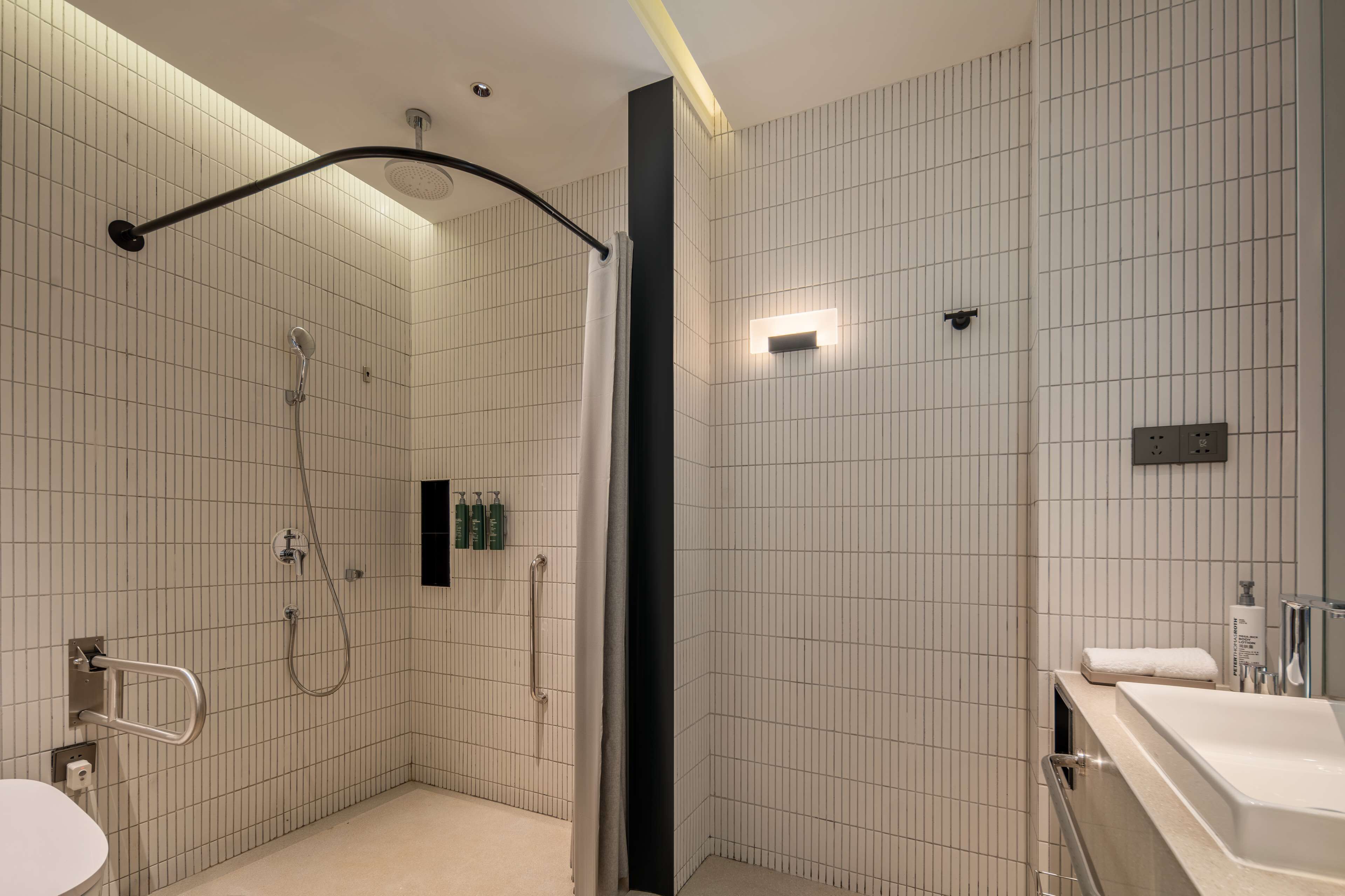 A modern bathroom with a shower, a toilet, and a sink.