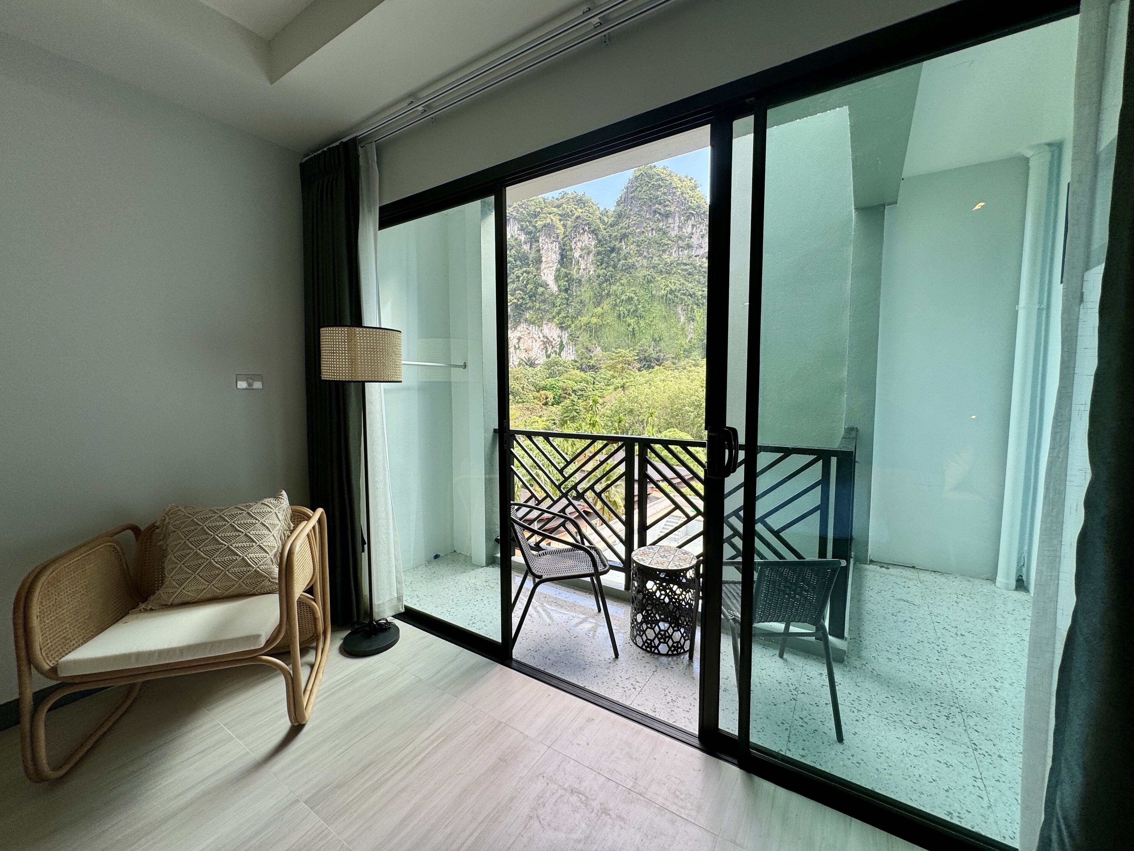 A room with a sliding glass door leading to a balcony with outdoor furniture.
