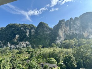 A mountainous landscape with dense forest and a few buildings with dark roofs. - Keereen Resort - Ao Nang Krabi (Krabi)