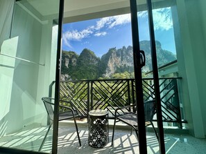 A balcony with a table and chairs, overlooking a mountainous landscape. - Keereen Resort - Ao Nang Krabi (Krabi)