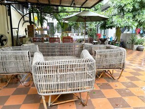 Wicker furniture under a covered patio area with a checkered floor. - Stay with local peoples! (Siem Reap)