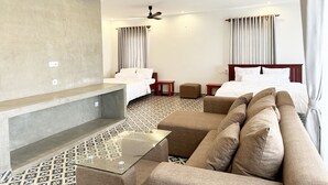 Ett hotellrum med en säng, en soffa, en tv och en takfläkt.