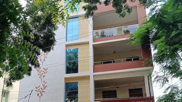 A multi-story building with a sign for 'Executive Service Apartment' at the ground level. - The Capital Executive Service Apartment (Guntur)