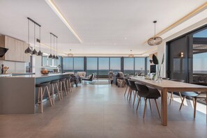 A modern kitchen with a central island, bar stools, and pendant lighting.