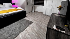 Un dormitorio con cama, mesita de noche, escritorio y armario.