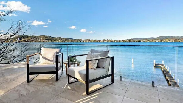 Two chairs with cushions on a patio overlooking a body of water with a dock. - Luxury Villas Clare De Lune Waterfront (with pool) (Central Coast)