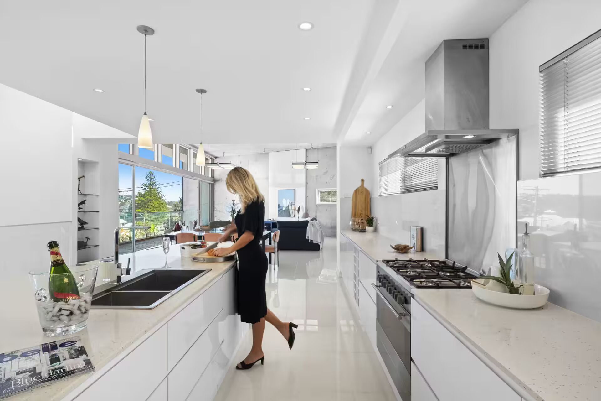 Een moderne keuken met een centraal kookeiland, een fornuis en een groot raam met uitzicht op de omgeving.