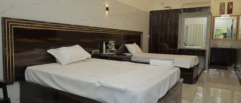 A hotel room with two beds, a large mirror, a vanity with a sink, and a marble floor.