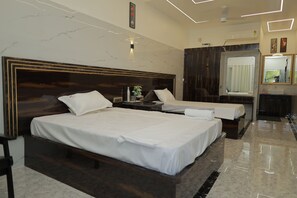 Une chambre d’hôtel avec deux lits, un grand miroir, une coiffeuse avec un lavabo et un sol en marbre.