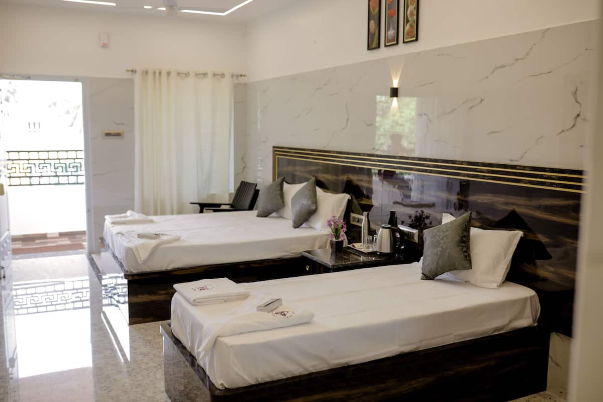 A hotel room with two beds, marble walls, a modern chandelier, and a view of the outside.