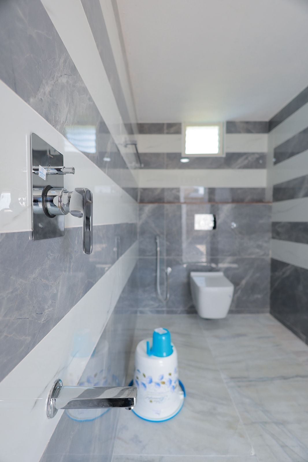 A modern bathroom with a shower, toilet, and a sink with a faucet.