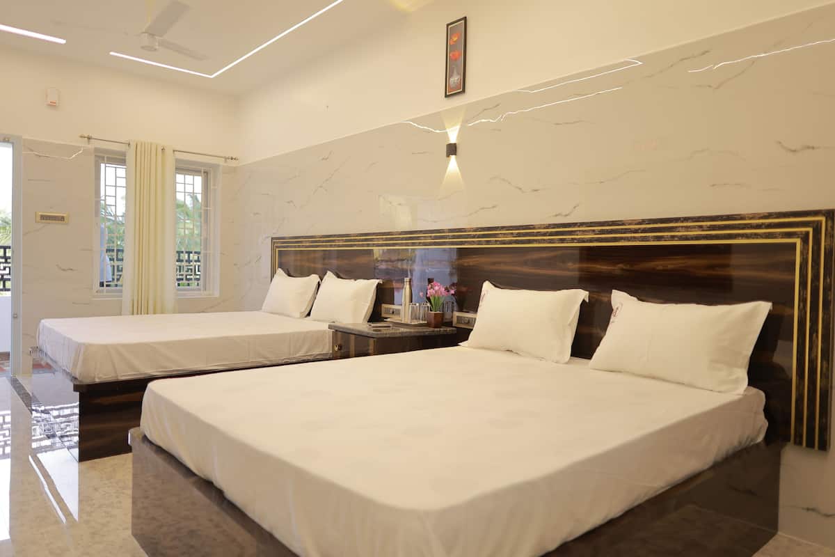 A hotel room with two beds, a marble wall, a ceiling fan, and a nightstand with a vase of flowers.