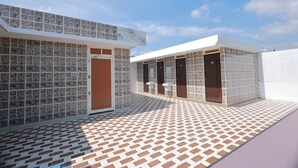Um edifício com fachada em azulejos, várias portas e chão padronizado.