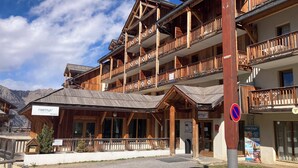 A wooden building with balconies, a reception area, and a no parking sign.